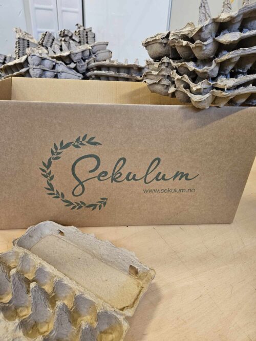 Logo for bedriften Sekulum og eggkartonger klare til pressing for å få fin form.