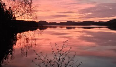 Solnedgang over innsjø