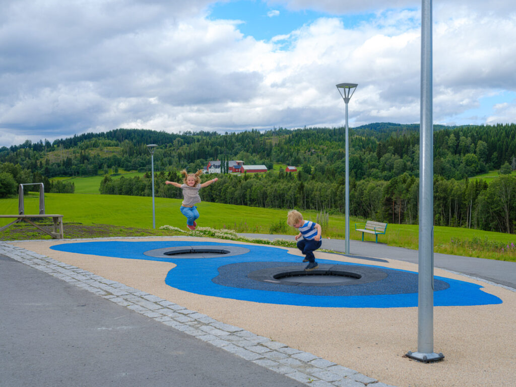 Barn hopper trampoline i lekeområde med fallunderlag.