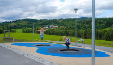 Barn hopper trampoline i lekeområde med fallunderlag.