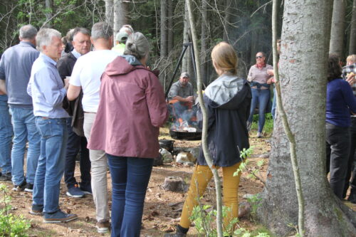 Gruppe med folk og bål i skogen.