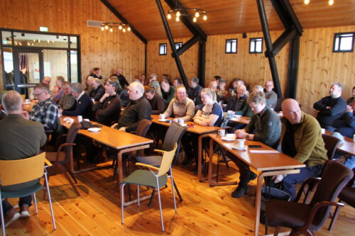 En gruppe folk på møte i et lokale.