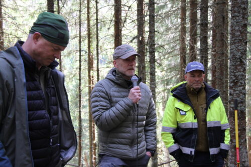 Mann holder innlegg i skogen.