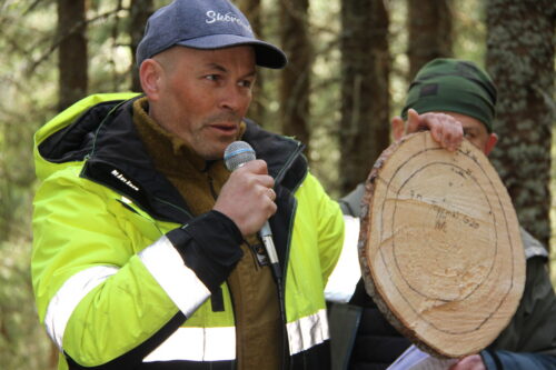 Mann holder foredrag i skogen.