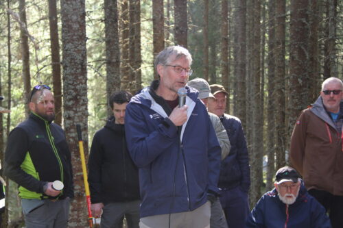 Mann holder innlegg i skogen.