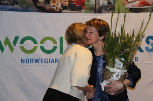 Dame overrekker blomst til ei dame.